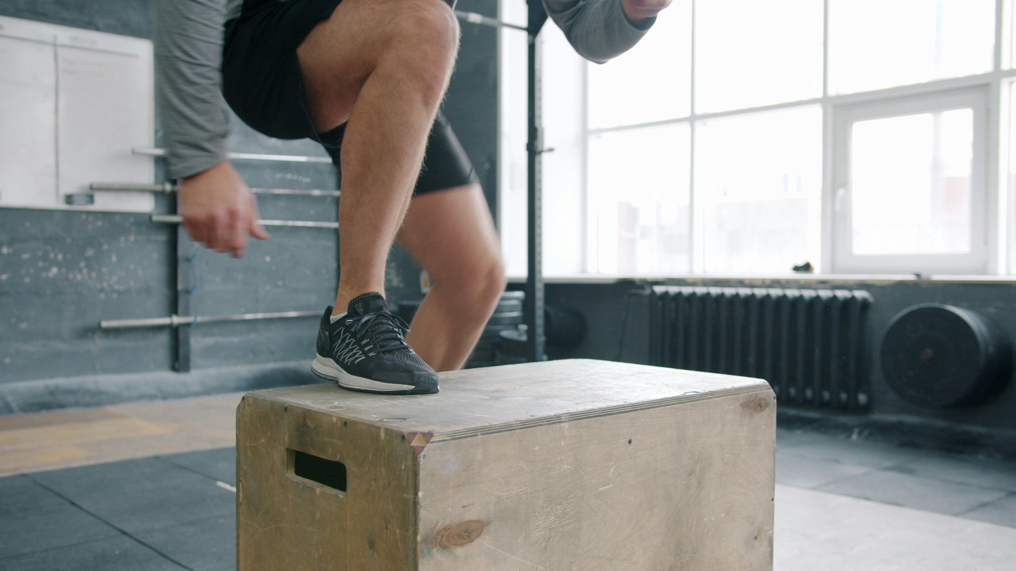 Functional training programs A person stepping onto a plyometric box to mimic a realistic motion of stepping up onto something and pushing yourself up.